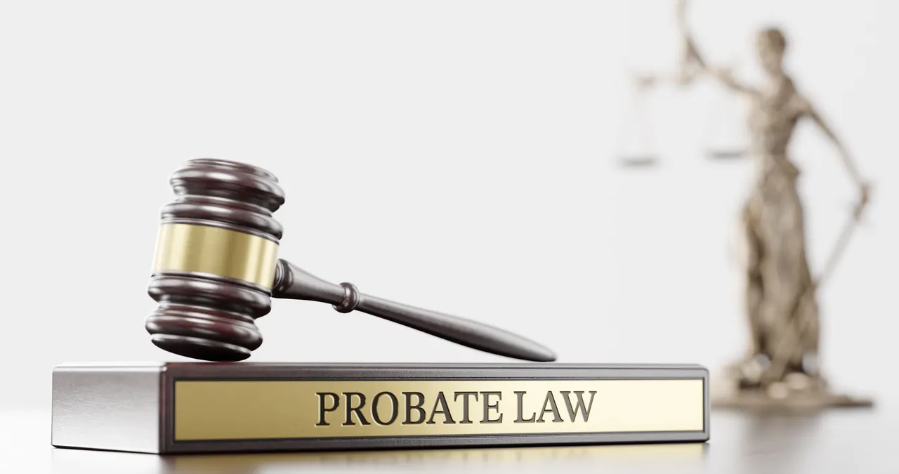 Gavel on a Probate Law nameplate with a Lady Justice statue behind it