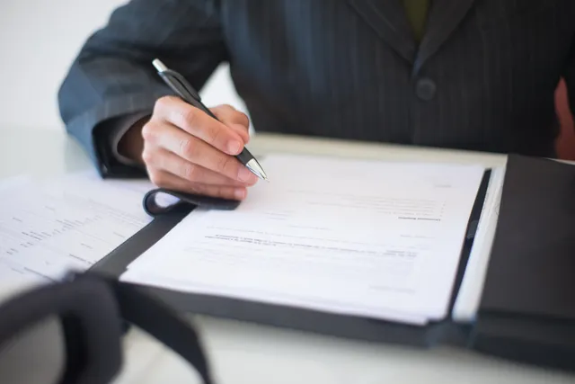 Client signing estate planning documents at a desk